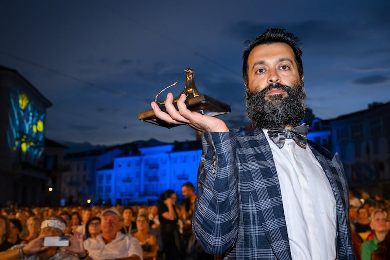Sina Ataeian Dena, producer of Mantagheye bohrani (Critical Zone), accepts the Golden Leopard at the Locarno International Film Festival on behalf of director Ali Ahmadzadeh. EPA