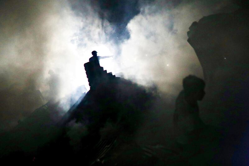 A man is silhouetted at the spot after a fire broke out in a slum in Dhaka, Bangladesh. REUTERS