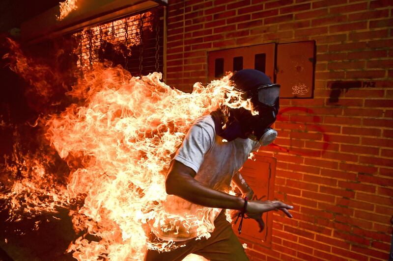 Ronaldo Schemidt won Picture of the Year 2018 for this shot which shows demonstrator Jose Victor Salazar Balza catching fire during clashes with riot police at a protest against Venezuelan President Nicolas Maduro, in Caracas, Venezuela. EPA/RONALDO SCHEMIDT/AFP