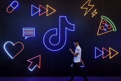 A man holding a phone walks past a sign of Chinese company ByteDance's app TikTok, known locally as Douyin, at the International Artificial Products Expo in Hangzhou, Zhejiang province, China October 18, 2019. Picture taken October 18, 2019.  REUTERS/Stringer  ATTENTION EDITORS - THIS IMAGE WAS PROVIDED BY A THIRD PARTY. CHINA OUT.