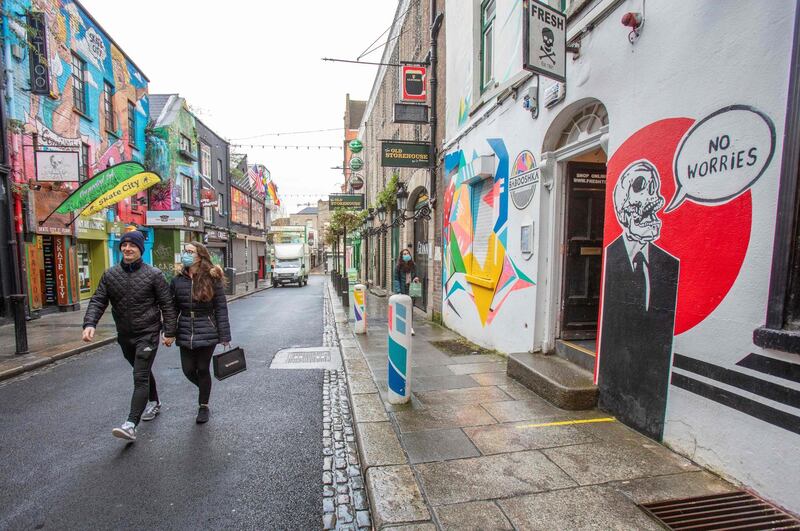 Members of the public walk down a quiet shopping street in Dublin on December 31. AFP