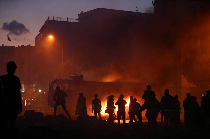 People gather as a truck is seen on fire during the protest in Martyr's Square. Reuters