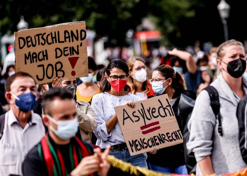 Protesters hold placards supporting asylum for Afghans during a rally in Berlin, Germany. EPA