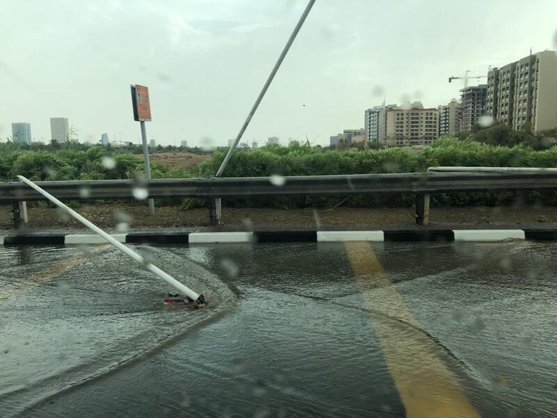 Sign posts keel over after a storm sweeps through Dubai on Friday. The National