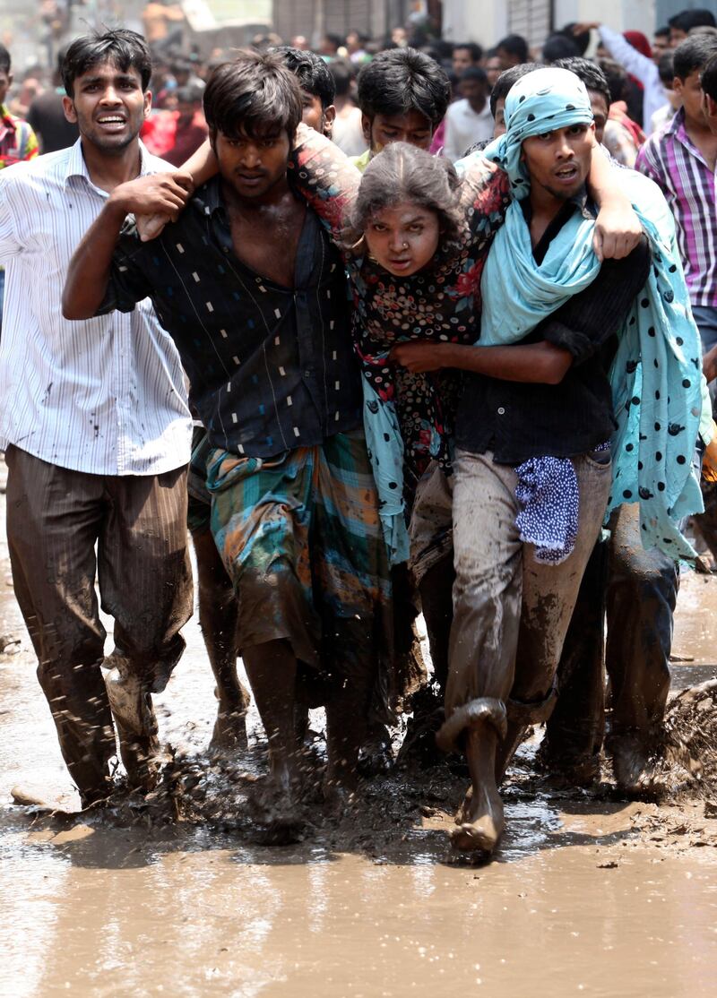 epa03674809 Civilians rescue an injured garment worker during a rescue operation after the eight-storey Rana Plaza building collapsed at Savar in Dhaka, Bangladesh, 24 April 2013. At least 20 people died including garment workers and many more were critically injured, reports said.  EPA/ABIR ABDULLAH *** Local Caption ***  03674809.jpg