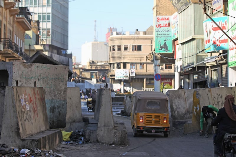 A tuk-tuk drives through a barricade at Al Rashid street in the Iraqi capital Baghdad amid ongoing anti-government demonstrations. AFP