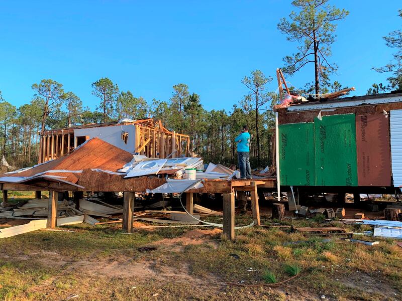 A homeowner stands in the middle of his trailer home cut in half by a tornado that touched down on Wednesday, in Vancleave, Mississippi. The Sun Herald / AP