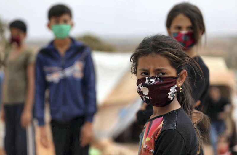 Children wear face masks sewed by displaced Syrian women at a camp for the internally displaced people near the town of Maaret Misrin in Syria's northwestern Idlib province on July 27, 2020 amid the COVID-19 pandemic crisis. (Photo by AAREF WATAD / AFP)