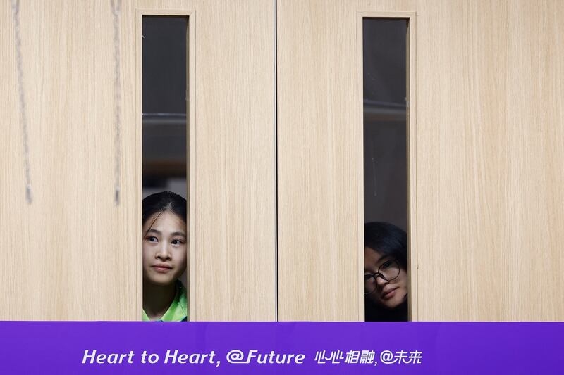 Volunteers watch the squash medal ceremony through the doors Asian Games in Hangzhou, China. Reuters 