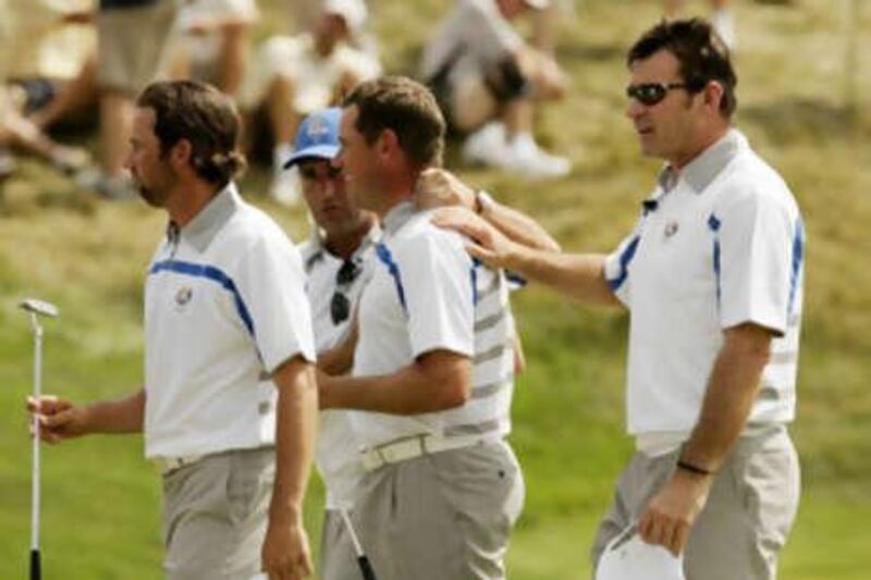 Europe's Sergio Garcia, left, and Lee Westwood, second from right, are congratulated by team captain Nick Faldo, right, and Jose Maria Olazabal after halving their match.