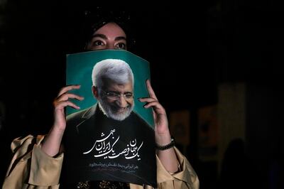 A supporter of Saeed Jalili, a candidate in Iran's presidential election, holds up his poster during a campaign gathering in Tehran on Wednesday. AP Photo