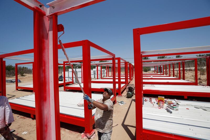 A worker paints frames of containers to be used for a coronavirus quarantine centre in the Gaza Strip. Reuters