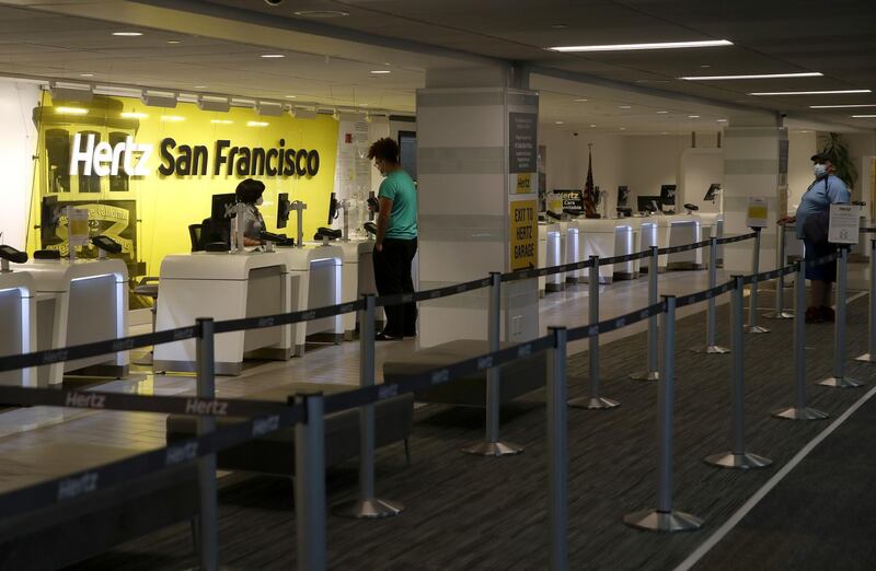 SAN FRANCISCO, CALIFORNIA - APRIL 30: Two customers wait in line to rent a car from Hertz at San Francisco International Airport on April 30, 2020 in San Francisco, California. According to a report in the Wall Street Journal, car rental company Hertz is preparing to file for bankruptcy as the travel industry has come to a standstill due to the coronavirus (COVID-19) pandemic.   Justin Sullivan/Getty Images/AFP
== FOR NEWSPAPERS, INTERNET, TELCOS & TELEVISION USE ONLY ==
