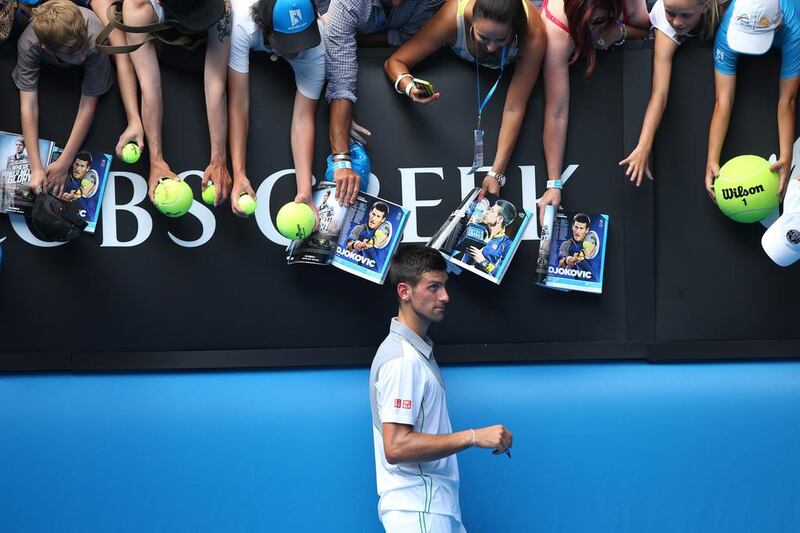 Novak Djokovic signs autographs for fans after winning his second round match against Leonardo Mayer of Argentina. Chris Hyde / Getty Images