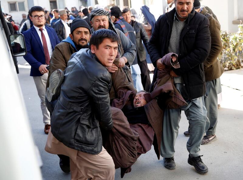 People carry a mourning man from a hospital in Kabul. Mohammad Ismail / Reuters