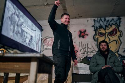 Chaplain Leonid, a policeman, preaches as he shows a religious Christmas film with a generator and TV set in an apartment house basement used as a bomb shelter in Avdiivka, Donetsk region. AP Photo