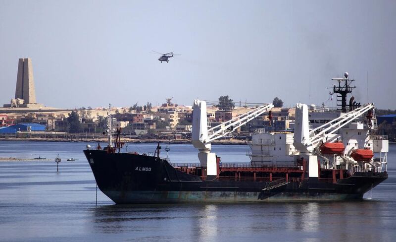 A military helicopter flies above a container ship in the Suez Canal. Amr Abdallah Dalsh / Reuters