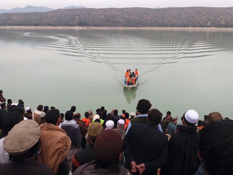 Rescue workers search the Tanda Dam after the boat capsize. EPA