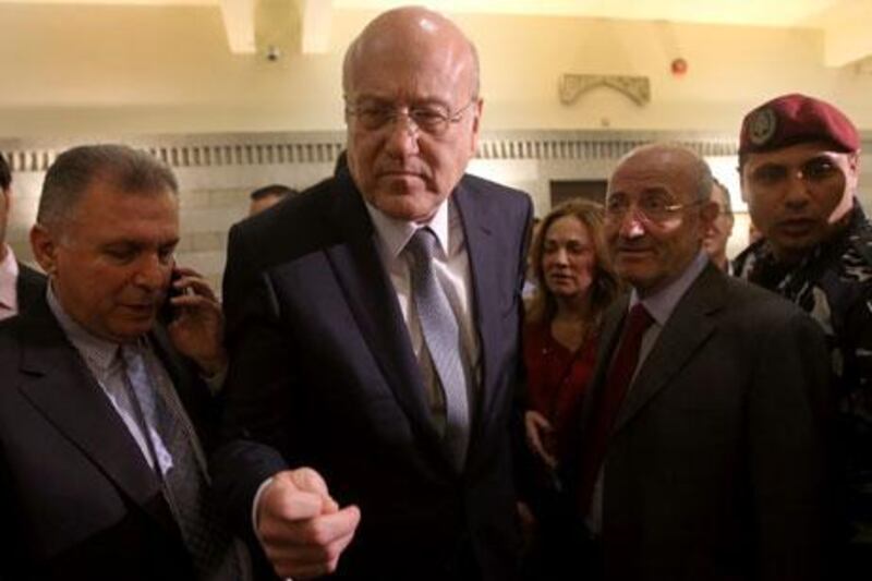 The resignation of Nijab Mikati, centre, as prime minister may be an attempt to boost his credentials among his fellow Sunnis ahead of elections. Hussein Malla / AP Photo