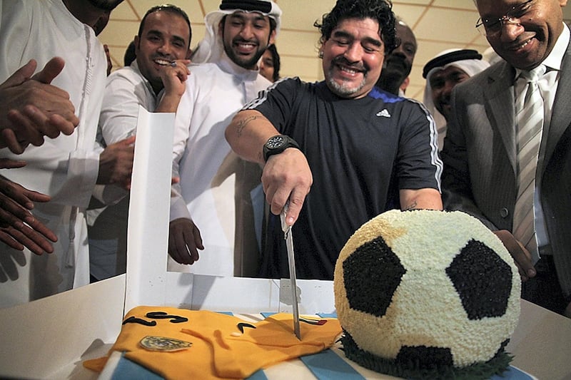 EDITOR'S NOTE--RESTRICTED TO EDITORIAL USE - MANDATORY CREDIT "AFP PHOTO /AL-WASL CLUB"  - NO MARKETING NO ADVERTISING CAMPAIGNS - DISTRIBUTED AS A SERVICE TO CLIENTS - 
A handout picture made available by the UAE's Al-Wasl club shows Argentinian football legend and Al-Wasl team coach, Diego Maradona, cutting a cake during a celebration marking his 51st birthday in Dubai, on October 30, 2011. Maradona was presented with a special jersey signed by all the players on the team.  AFP PHOTO/HO/AL-WASL CLUB (Photo by - / AL-WASL CLUB / AFP)
