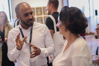 Artist Khalid Alnajdi speaking to a visitor at the 'In My Dream I Was in Kuwait' exhibition in Venice. Courtesy of ASCC