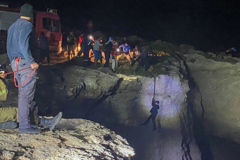 A migrant hangs from a rope during a rescue operation following a shipwreck, on the island of Kythira, Greece, October 5, 2022.  REUTERS/Ippolitos Prekas NO RESALES.  NO ARCHIVES