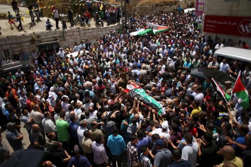 Mourners carry the body of Palestinian Abdullah Ghanayem during his funeral in the village of Qafr Malik near Ramallah on June 14.  An Israeli army jeep struck and killed Ghanayem in the occupied West Bank on Sunday. REUTERS