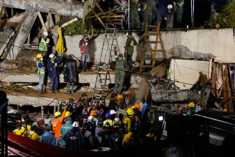 Rescue personnel work on the rescue of a trapped child at the collapsed Enrique Rebsamen primary schoool. Marco Ugarte / AP Photo
