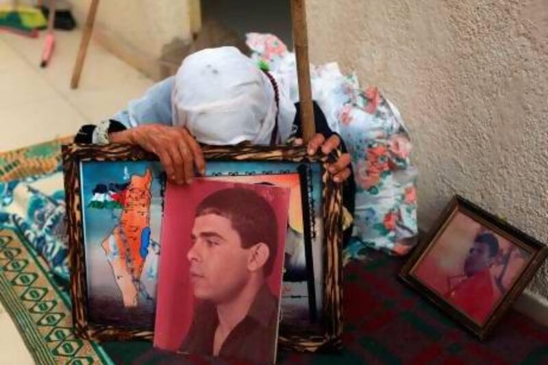 The mother of Palestinian Fares Baroud, who has been held in an Israeli prison for 22 years, cries as she holds his picture after hearing news on the possible release of her son at her house in Shati refugee camp in Gaza City.