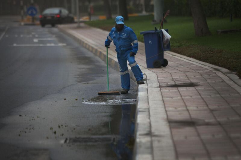 ABU DHABI, UNITED ARAB EMIRATES - - -  April 7, 2013 ---  A worker pushes water into a draining along Airport Road inAbu Dhabi on Sunday after the city was hit with rain and sand storms.   ( DELORES JOHNSON / The National )