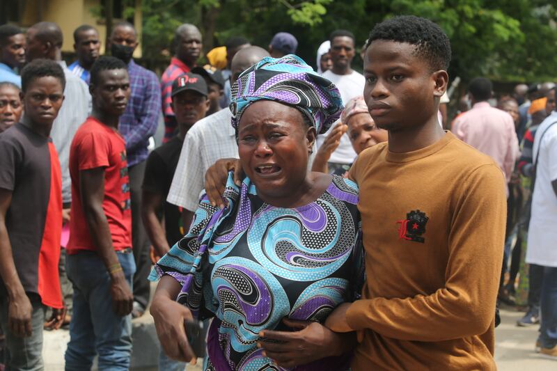 A woman who is a relative of a victim of the disaster is supported by family members at the site.  EPA