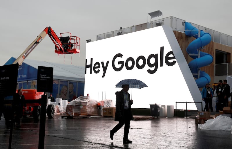 FILE PHOTO: A man walks through light rain in front of the Hey Google booth under construction at the Las Vegas Convention Center in preparation for the 2018 CES in Las Vegas, Nevada, U.S. January 8, 2018. REUTERS/Steve Marcus/File Photo                         GLOBAL BUSINESS WEEK AHEAD
