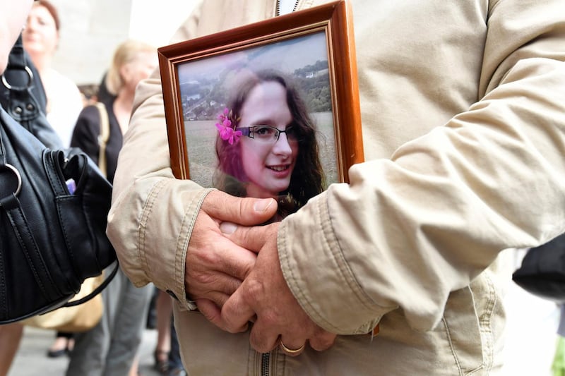 (FILES) In this file photo taken on June 06, 2018, a man holds a picture of murdered French au-pair Sophie Lionnet following her funeral in Sens.
 A French couple living in London who murdered their au-pair and tried to dispose of the body by burning it in their back garden were sentenced to life in prison, on June 26, 2018, with a minimum of 30 years. The Old Bailey court in London sentenced Sabrina Kouider, who is undergoing psychiatric treatment, and Ouissem Medouni for the September 2017 killing of 21-year-old Sophie Lionnet. / AFP / Bertrand GUAY
