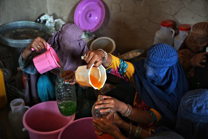 Burqa-clad women work in a shampoo factory in Kandahar. AFP