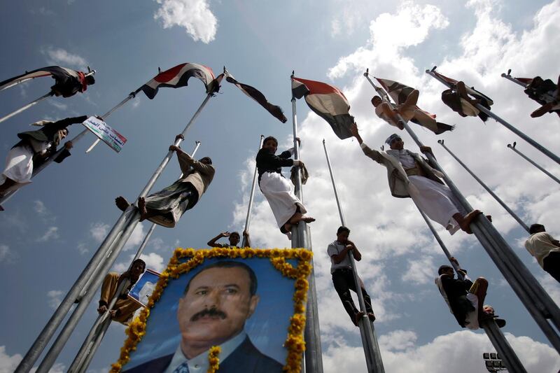 Supporters of Yemen's President Ali Abduallah Saleh stand on flag poles celebrating his return to Sanaa, Yemen, Friday, Sept. 23, 2011. President Ali Abdullah Saleh made a surprise return to Yemen on Friday after more than three months of medical treatment in Saudi Arabia in a move certain to further enflame battles between forces loyal to him and his opponents that have turned the capital into a war zone. (AP Photo/Hani Mohammed)