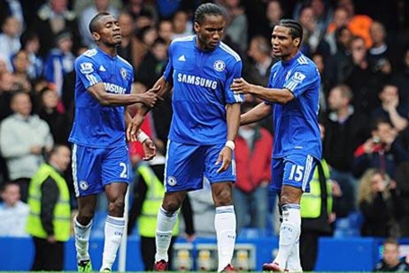 Didier Drogba, centre, is restrained by Chelsea teammates Florent Malouda, left, and Salomon Kalou after Frank Lampard refused to let the Ivorian take the side's first spot-kick against Wigan.