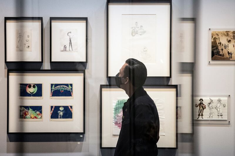 A visitor looks at drawings of 'Nightmare Before Christmas' characters. EPA