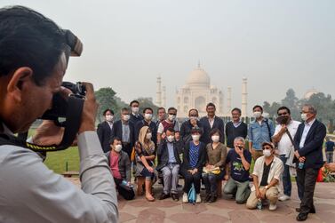 Tourists wear masks as they pose for photographs during their visit of the Taj Mahal amid heavy smog conditions. AFP