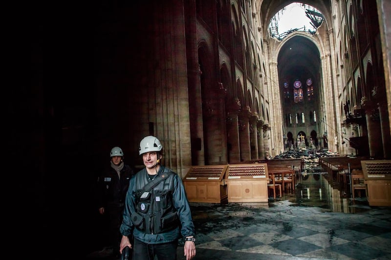 A staff member walks inside the Notre-Dame in the aftermath of a fire that devastated the cathedral. EPA