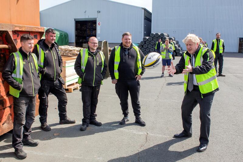 Britain's Prime Minister Boris Johnson catches a rugby ball during a visit to Next World Sports in Wrexham, Wales. Reuters