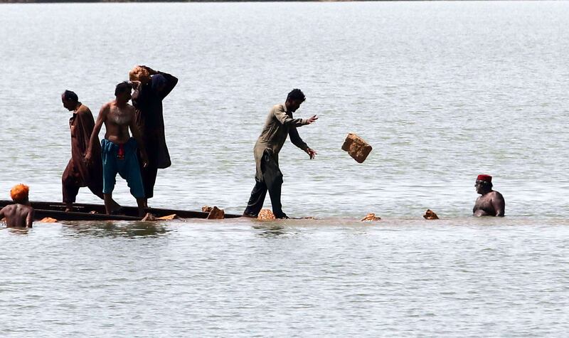 Pakistani railway workers repair the track in flooded areas in Sehwan, Sindh Province. EPA