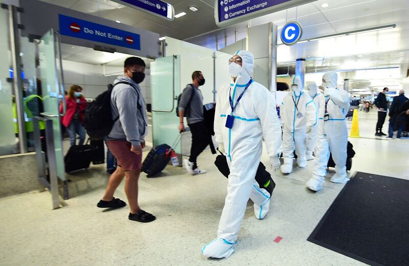 Air China crew members arrive at Los Angeles International Airport in hazmat suits after the county reported its first case of the Omicron variant. AFP