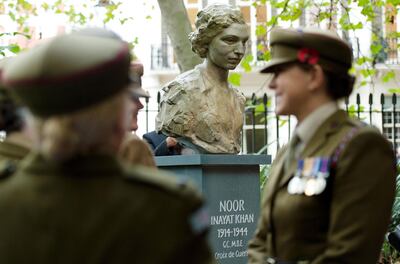 Members of the the First Aid Nursing Yeomanry (Princess Royal's Volunteer Corp) chat following a ceremony to unveil a statue of Noor Inayat Khan in Gordon Square Gardens, central London on November 8, 2012 in London, England. Noor Inayat Khan worked as a radio operator for the Women's Auxiliary Air Force before being recruited by the Special Operations Executive as an agent, working behind enemy lines in Paris, France.  She was eventually captured, tortured and beaten before being executed at Dachau Concentration Camp, aged 30. AFP PHOTO / LEON NEAL (Photo by LEON NEAL / AFP)