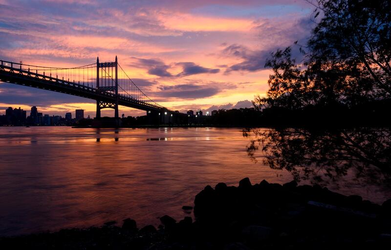 The sun sets behind the Robert F Kennedy Bridge in New York City, US. AFP