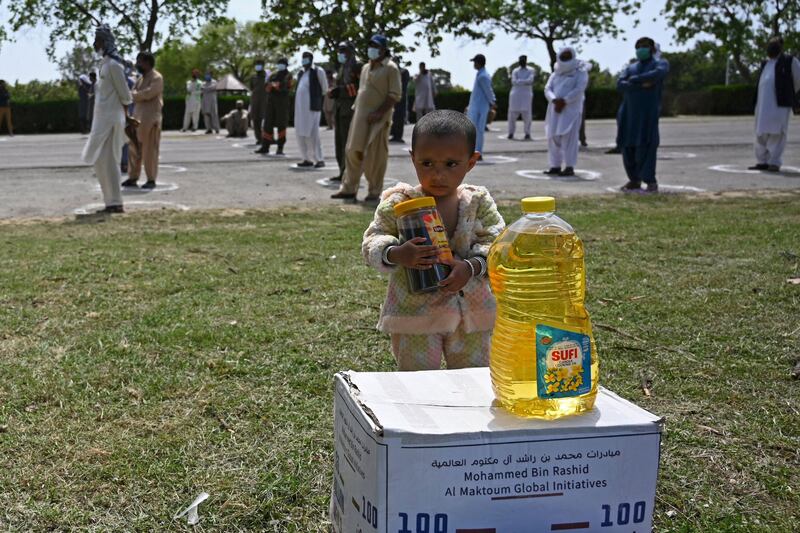 A child receives food distributed by the UAE embassy ahead of Ramadan in Islamabad.