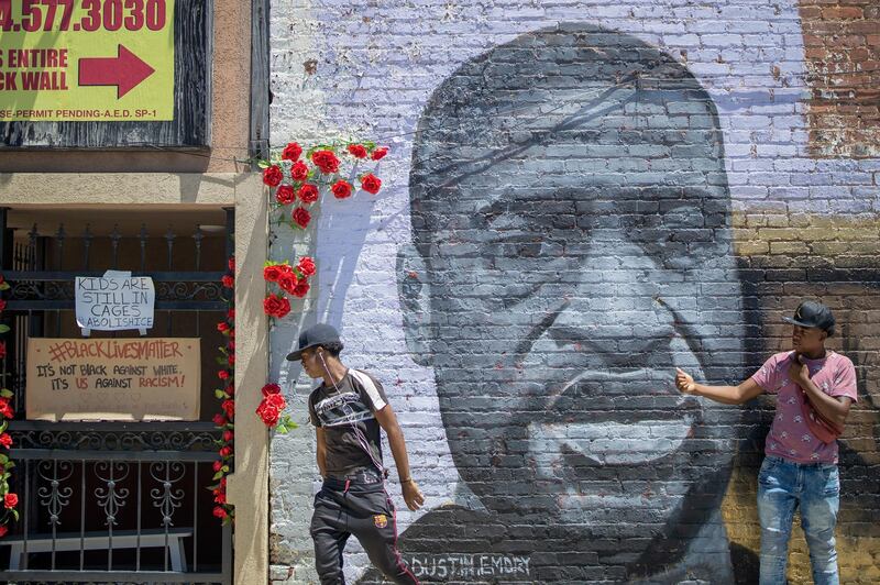 epa08479728 People pause at a newly painted George Floyd mural on a building near downtown Atlanta, Georgia, USA, 11 June 2020. Floyd's death while in the custody of the Minneapolis Police Department has sparked worldwide protests.  EPA/ERIK S. LESSER