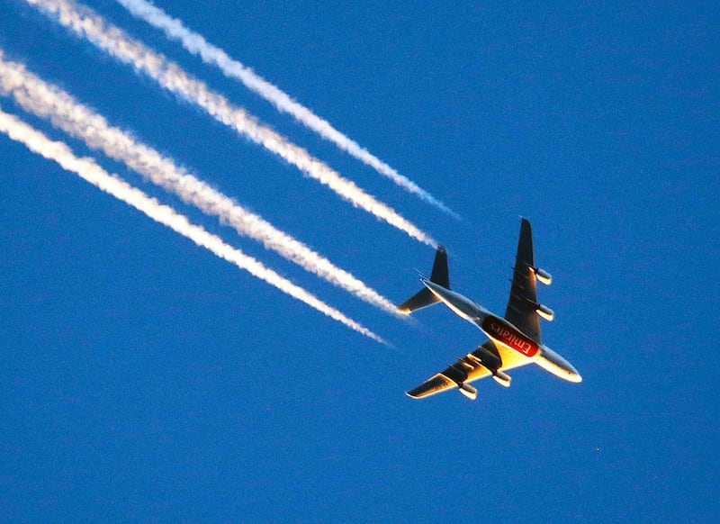 The four-engine aircraft of Emirates airline is illuminated by last rays of the sun as it flies over Frankfurt, Germany, Friday, March 10, 2017.(AP Photo/Michael Probst)