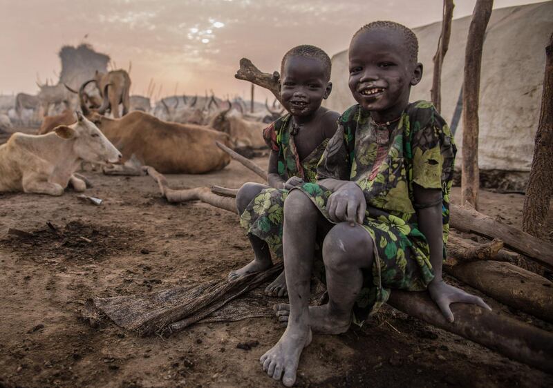 Two boys smile for the camera at the cattle camp.