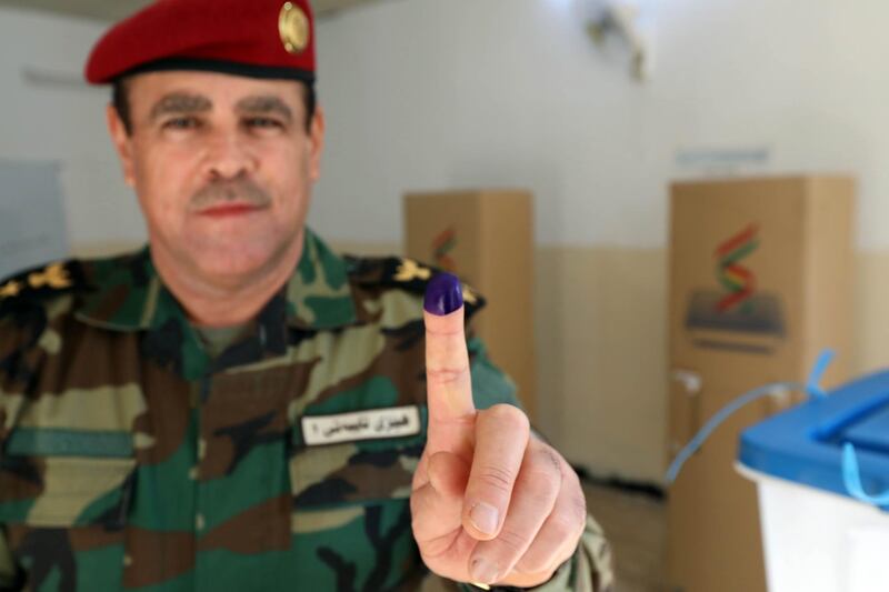 A member of a Kurdish Peshmerga battalion shows his ink-stained finger after casting his vote for the parliamentary election in Iraq's autonomous Kurdish region, in Arbil, on September 28, 2018 as Kurdish armed forces vote ahead of the general public. Voters in Iraq's Kurdistan elect a new parliament on September 30 with the autonomous region reeling from an economic crisis a year after a bid for independence backfired disastrously. / AFP / SAFIN HAMED
