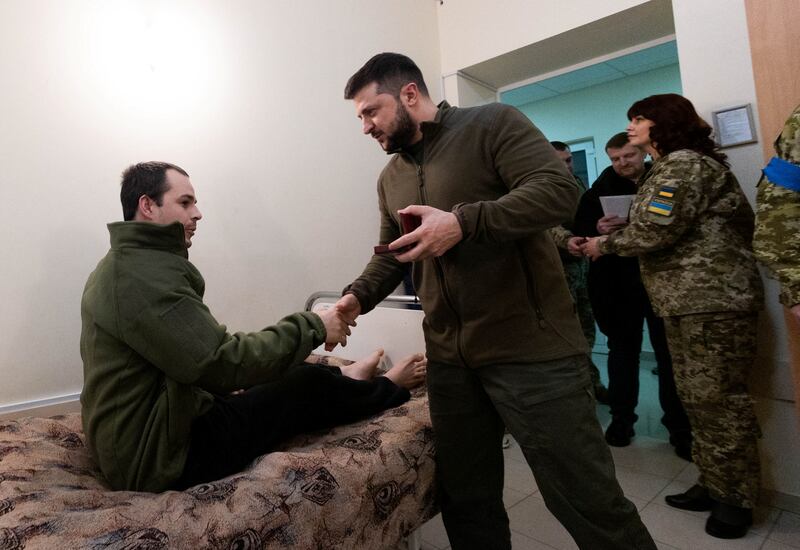 Ukraine's President Volodymyr Zelenskyy presents an award to an injured Ukrainian service member at a military hospital in Kyiv. Reuters